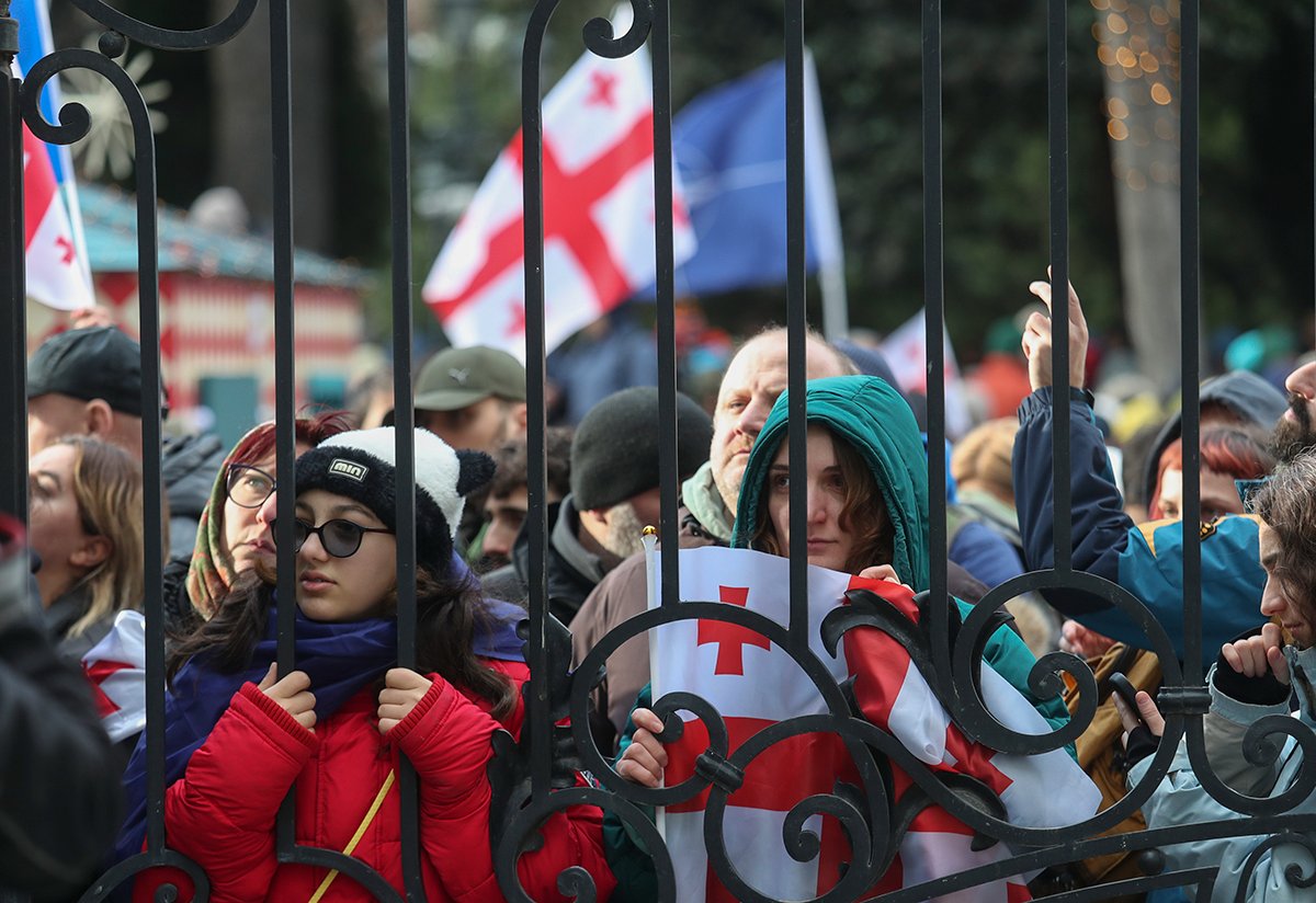 Люди слушают заявление уходящего президента Грузии Саломеи Зурабишвили перед дворцом Орбелиани в Тбилиси, 29 декабря 2024 года. Фото: David Mdzinarishvili / EPA