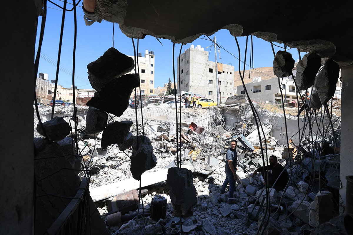 Палестинцы осматривают повреждения в мастерской по производству токарных станков возле лагеря беженцев Балата, недалеко от города Наблус на Западном берегу, 3 июля 2025 года. Фото: Alaa Badarneh / EPA