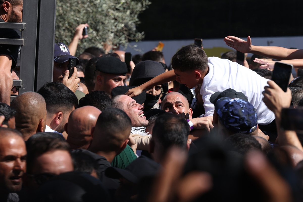 Люди встречают освобождённых палестинских заключённых по прибытии в Рамаллу, 13 октября 2025 года. Фото: Alaa Badarneh / EPA