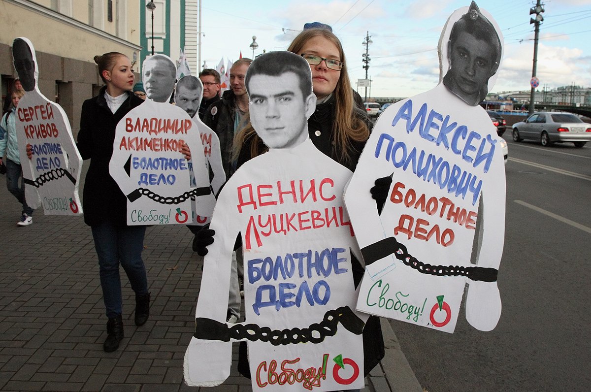 Молодые люди несут фотографии арестованных участников митинга на Болотной площади. Санкт-Петербург, 27 октября 2012 года. Фото: Анатолий Мальцев / EPA