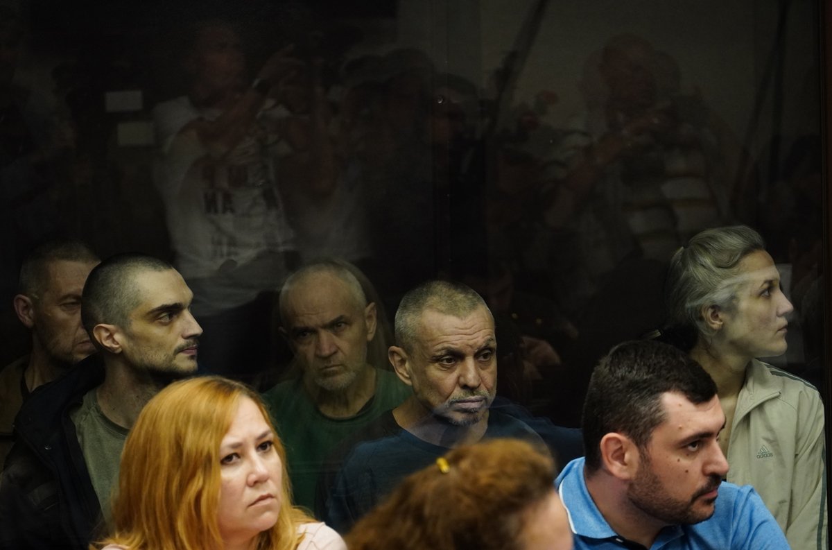 Украинские военнопленные (на заднем плане) сидят в клетке для подсудимых во время слушаний в Южном окружном военном суде в Ростове-на-Дону, 14 июня 2023 года. Фото: EPA