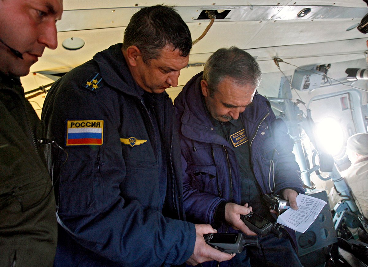 Офицеры российской поисково-спасательной группы работают с системами GPS на борту вертолета, Казахстан, 21 октября 2007 года. Фото: Сергей Пономарев / EPA