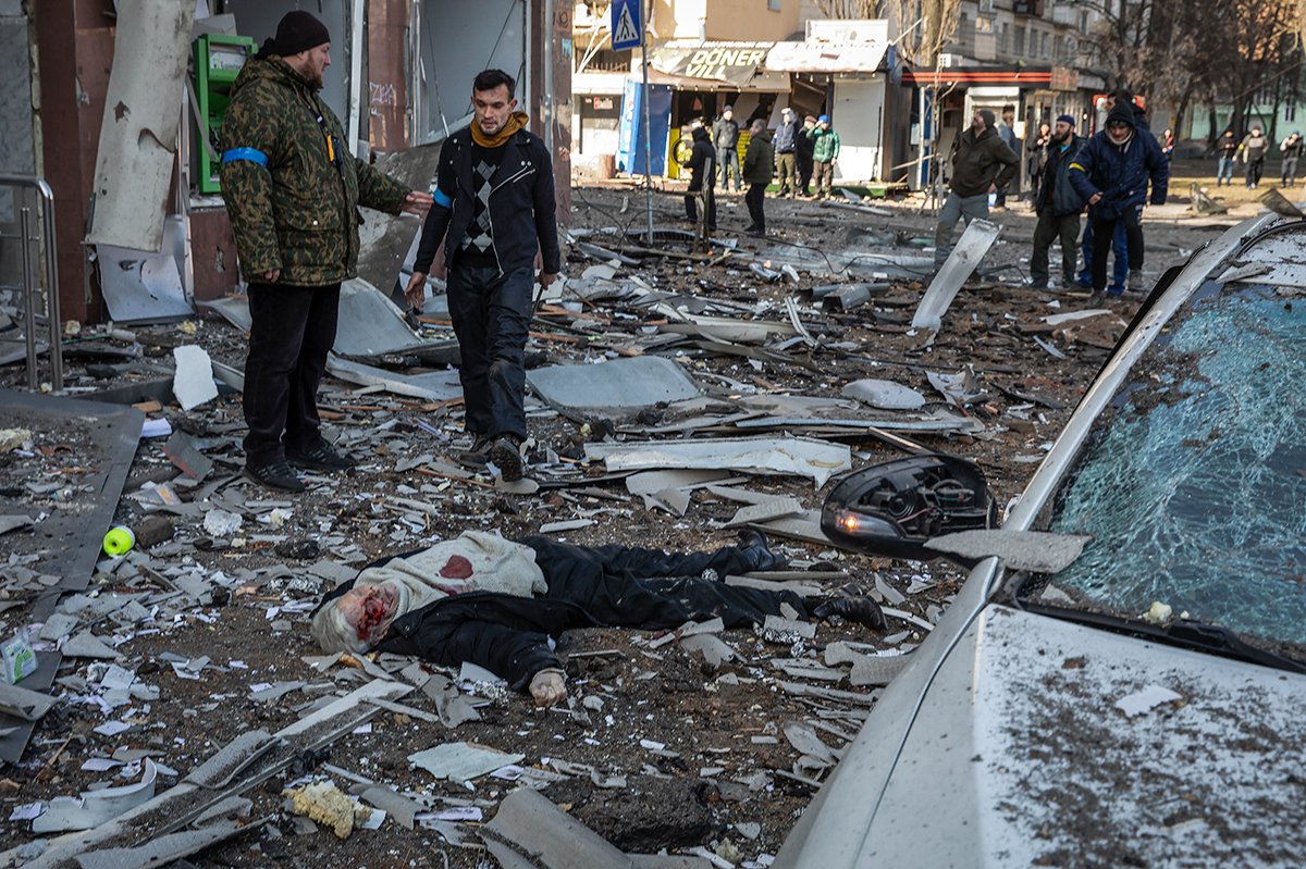 Тело мужчины, погибшего во время обстрелов, лежит на улице рядом с жилыми домами в Оболонском районе Киева, Украина, 14 марта 2022 года. Фото: Mikhail Palinchak / EPA-EFE