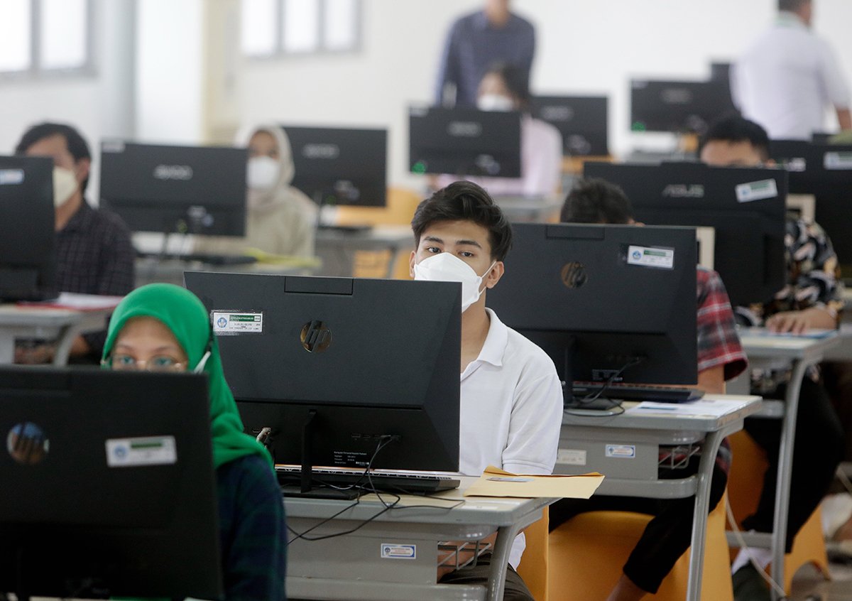 Студенты в защитных масках сдают вступительные экзамены в университет UPN Veteran в Депоке, Индонезия, 9 мая 2023 года. Фото: Adi Weda / EPA-EFE