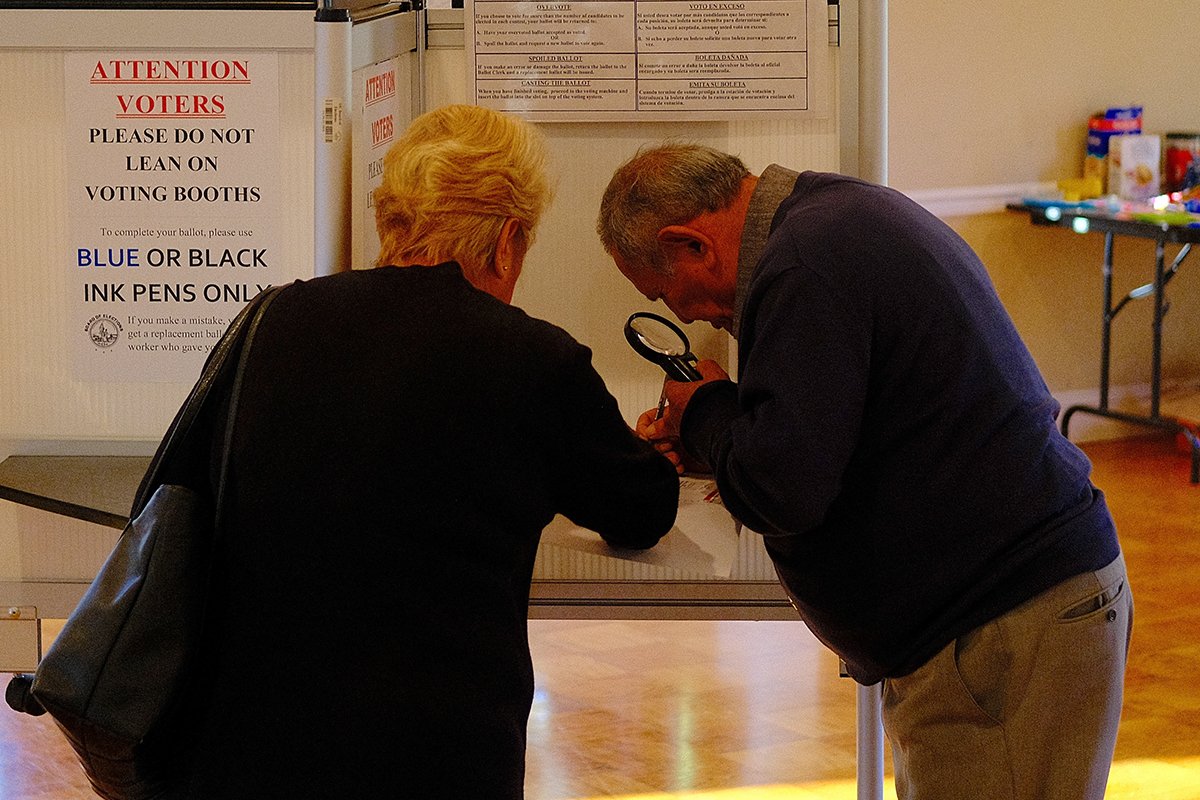 Избиратель с увеличительным стеклом заполняет бюллетень на избирательном участке в церкви Благовещения Пресвятой Богородицы в Вашингтоне, округ Колумбия, 5 ноября 2024 года. Фото: Gamal Dia