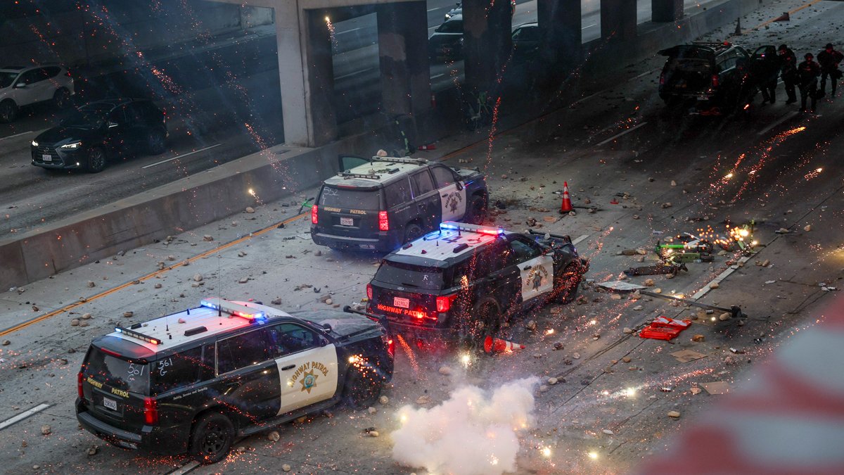 Протестующие закидывают полицейские автомобили камнями и запускают в них фейерверки, Лос-Анджелес, 8 июня 2025 года. Фото: Allison Dinner / EPA